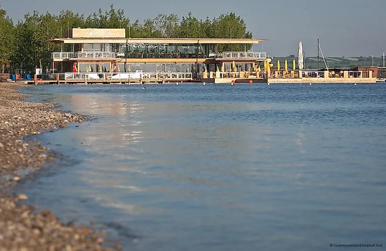 Moderner Bootssteg mit Gastronomie am ruhigen Ufer des Neusiedler Sees bei Rust.