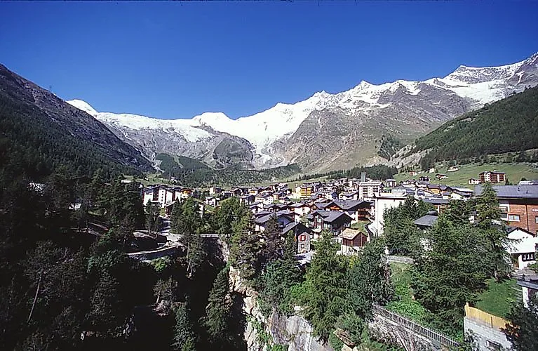 Vista sul villaggio montano di Saas-Fee con ghiacciai e panorama alpino in estate.