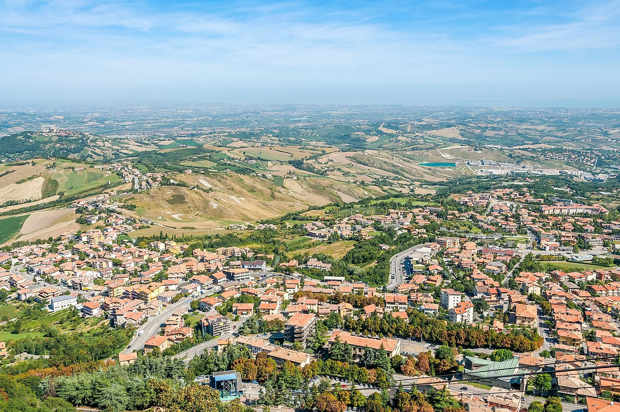 Pohľad zo San Marina na Borgo Maggiore a mierne zvlnené kopce na pobrežie Jadranského mora