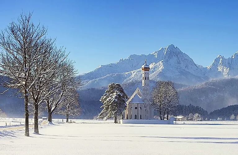L'église baroque Saint-Coloman dans un décor de montagnes enneigées à Schwangau