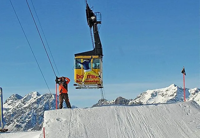 Kabelbaan over een besneeuwde piste in het skigebied van Bormio met uitzicht op de besneeuwde Alpen