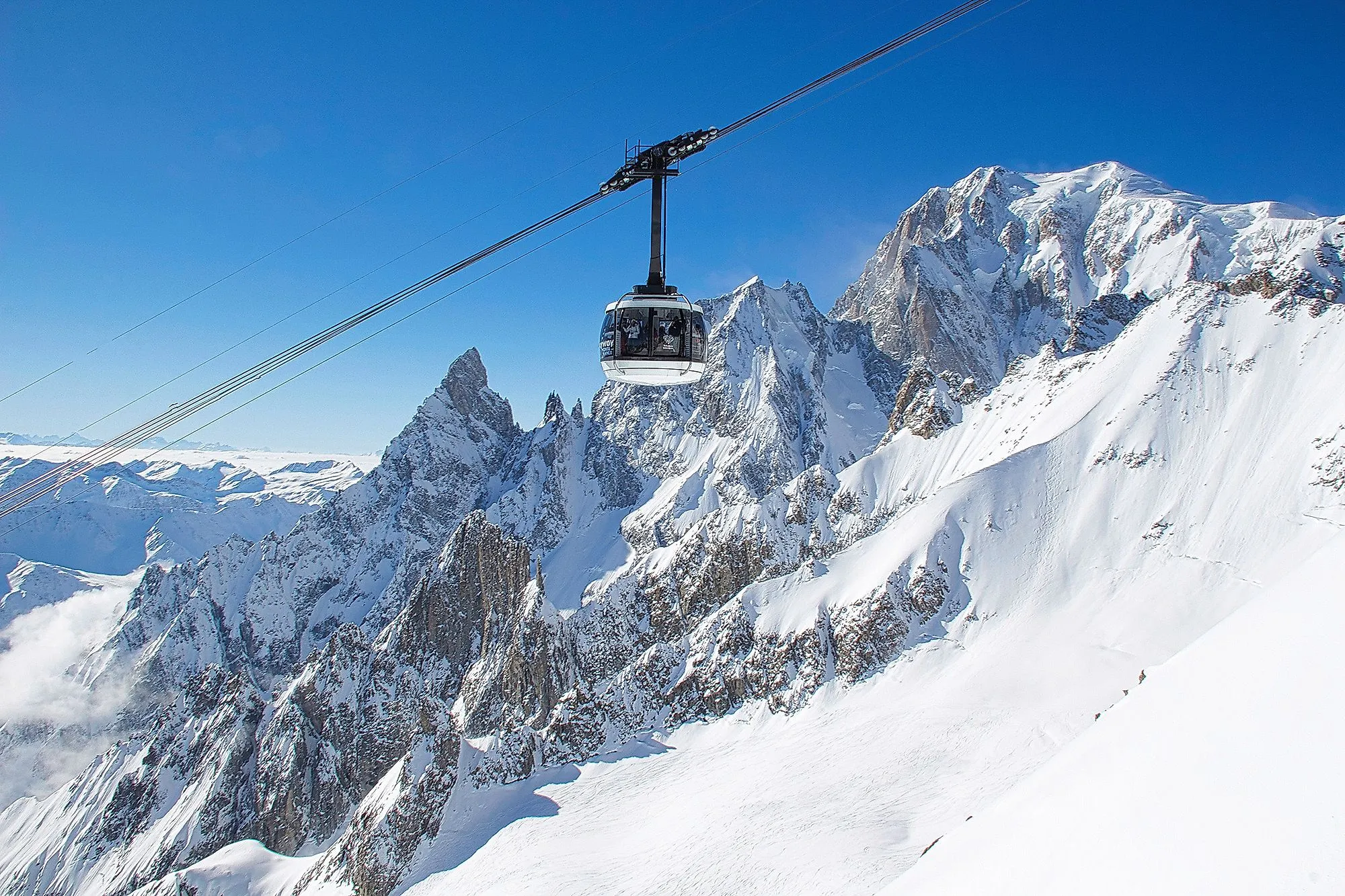 Gondola se vznáší před zasněženými vrcholky nedaleko Courmayeuru v údolí Aosta