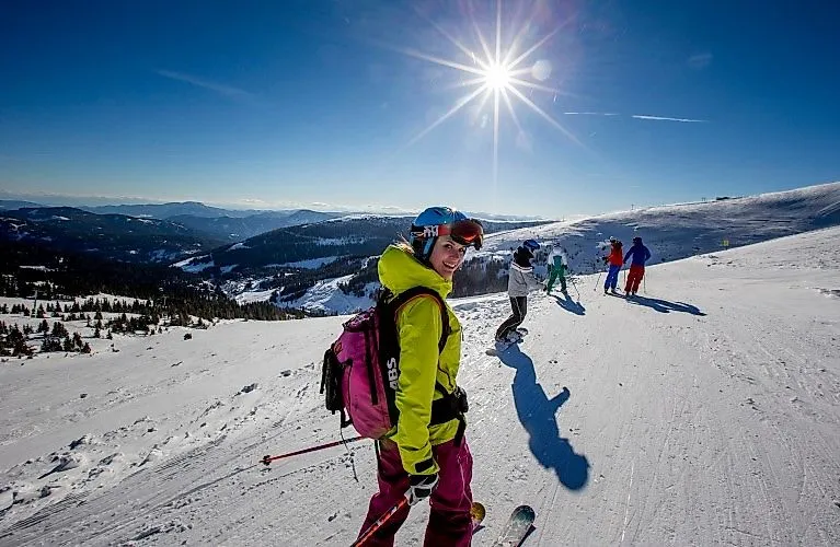 Lyžaři si užívají slunečný zimní den na sjezdovce v údolí Lachtal s nádherným panoramatickým výhledem.