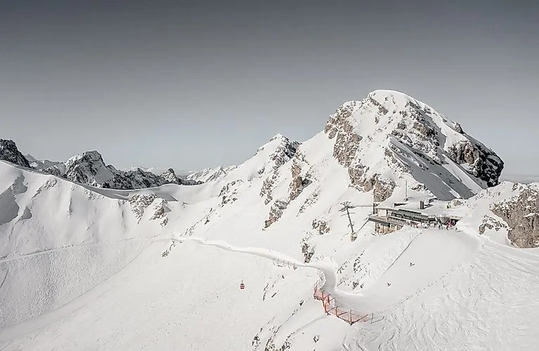 Skifahrergruppe vor verschneiter Kulisse bei La Videmanette in Rougemont mit Blick auf markante Gipfel im Winter.