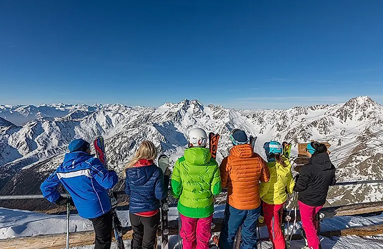 Skupina lyžařů si v zimě užívá panoramatický výhled na zasněžené hory ve Val Senales.