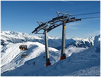 Sessellift über schneebedeckten Hängen mit Blick auf die verschneite Berglandschaft im Skigebiet Surcuolm – Piz Mundaun.