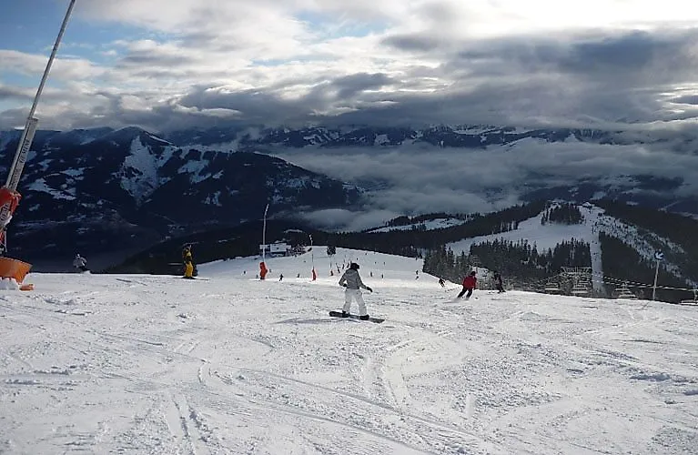 Sciatori sullo Schmittenhöhe con vista sulle montagne innevate vicino a Zell am See