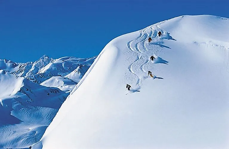Skifahrer fahren im Tiefschnee in St. Anton am Arlberg bei Sonnenschein