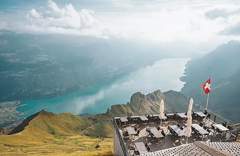 Viewing terrace on the Brienzer Rothorn with a view over the turquoise-green Lake Brienz and the surrounding mountains in summer.