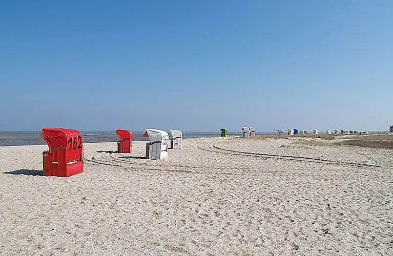 Large plage de sable sur la côte de la mer du Nord à Hooksiel avec des chaises de plage rouges et blanches par une journée ensoleillée