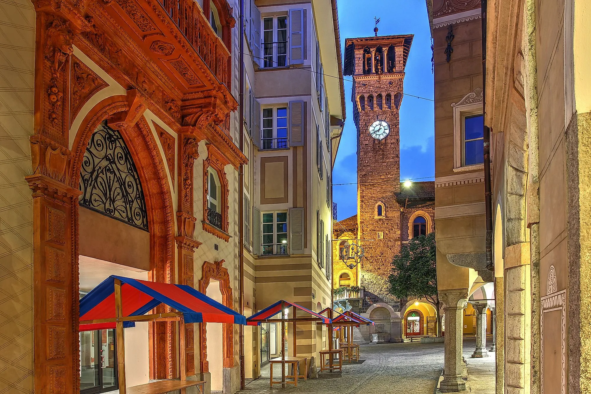 Večerní atmosféra ve starém městě Bellinzona s osvětlenou hodinovou věží a uličkami