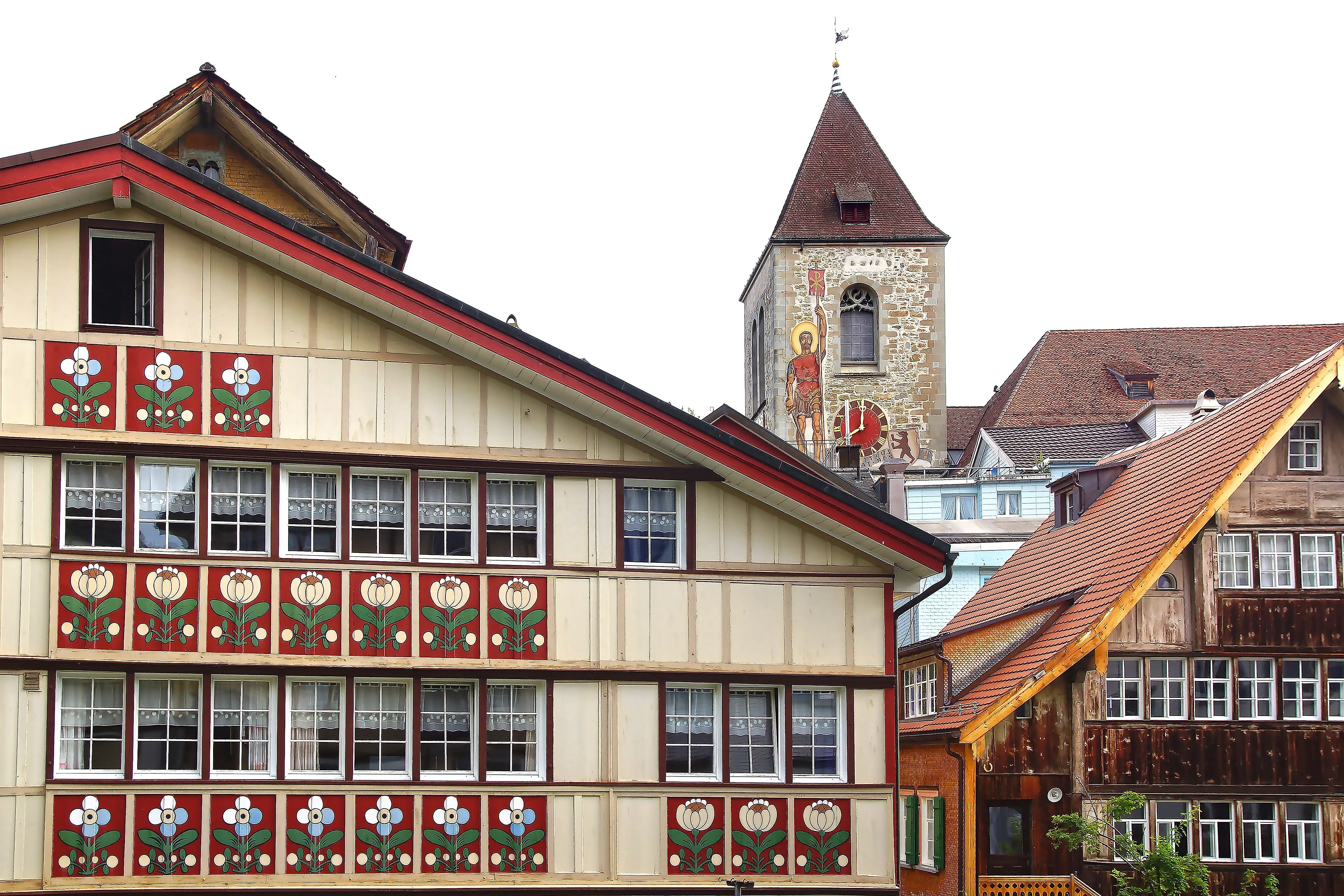 Traditioneel beschilderde huisgevel in Appenzell met kerktoren op de achtergrond