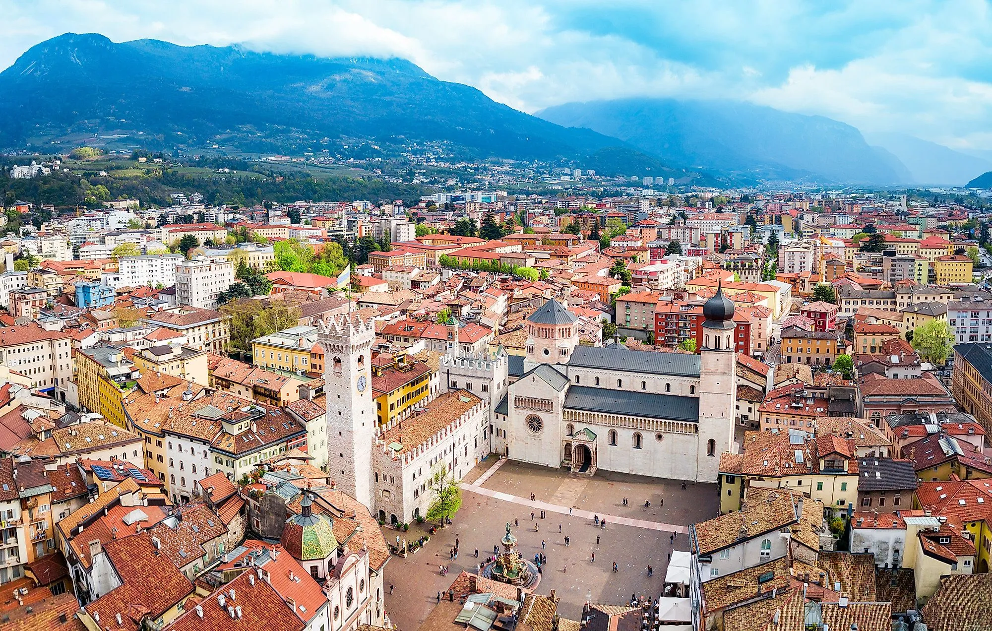 Historické staré město Trento s katedrálním náměstím a katedrálou San Vigilio, obklopené horami.