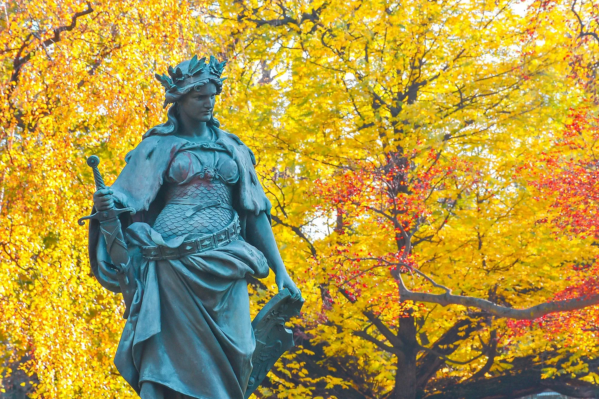 Statue in Graz City Park in front of colorful autumn trees