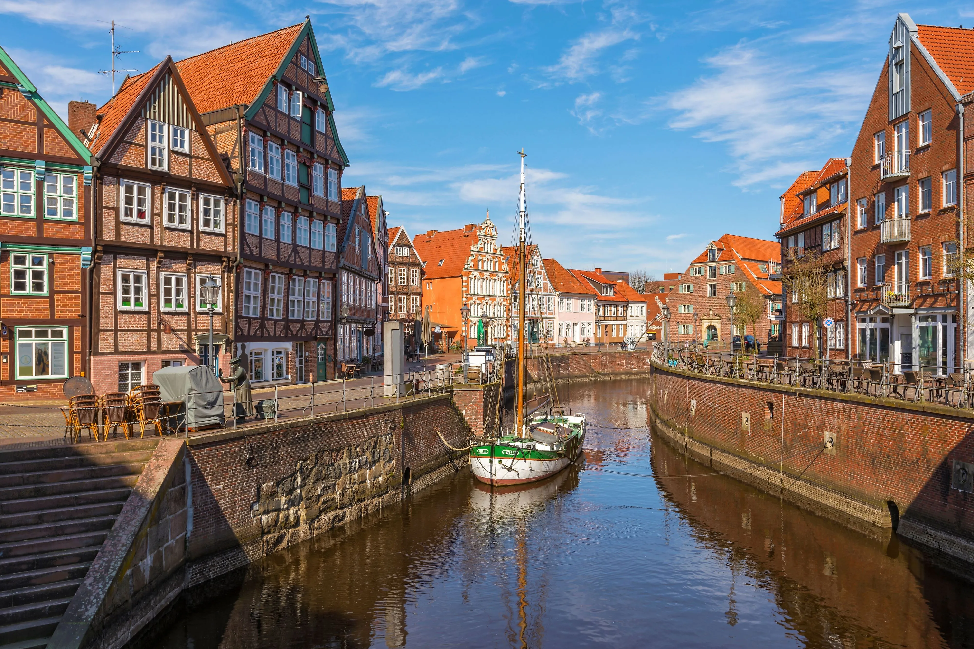 Historische vakwerkhuizen aan de oude haven in Stade met zeilboot in het water