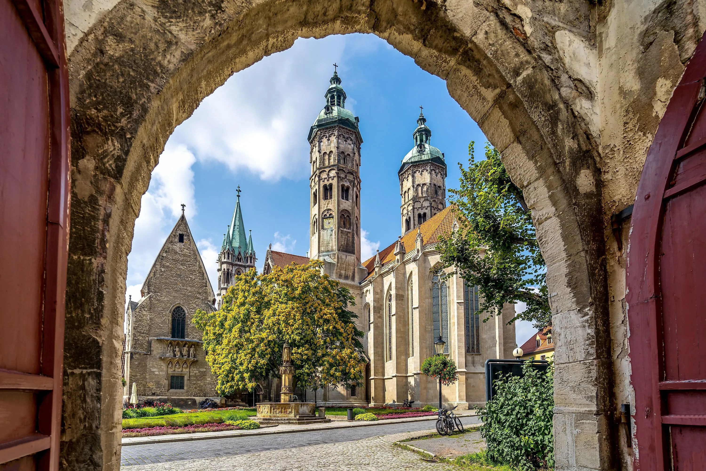 Cathédrale de Naumburg en Saxe-Anhalt avec tours et jardin, vue à travers une porte