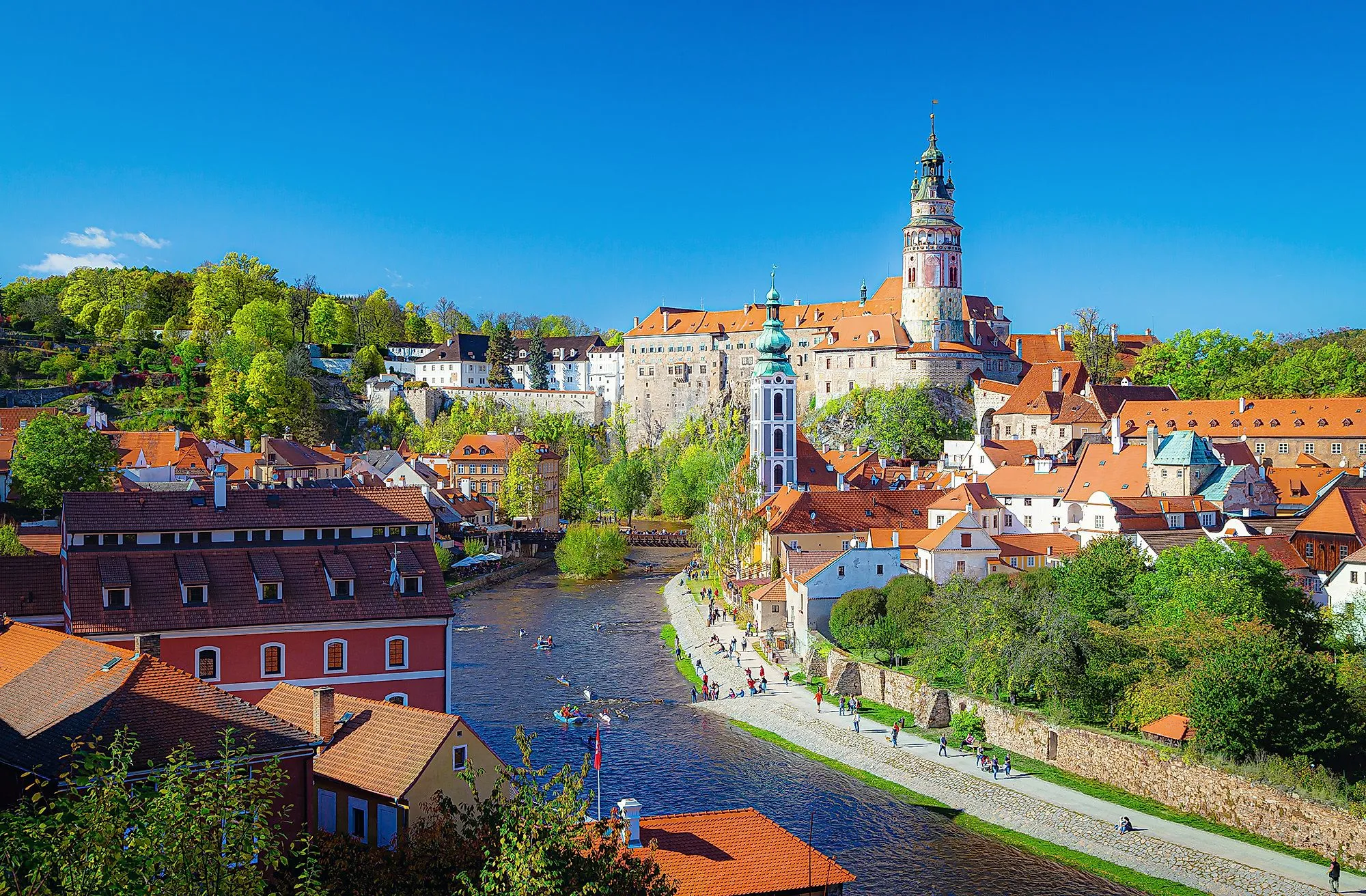 Historische Altstadt von Český Krumlov mit Schloss und Moldaufluss bei sonnigem Wetter.