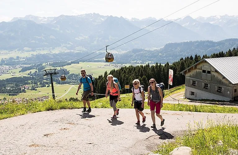 Escursionisti alla funivia Hörnerbahn di Bolsterlang - giornata di sole con vista sulla valle e sulle Alpi dell'Allgäu