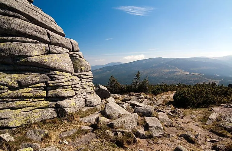 Značená turistická stezka na Šumavě s výhledem na zalesněné kopce