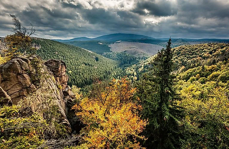 Vue sur les forêts et les rochers aux couleurs de l'automne dans les montagnes du Harz, sous un ciel dramatique.