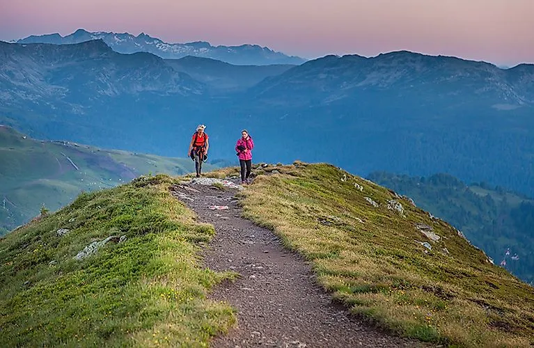 Dos excursionistas en el Schoberriegel al amanecer en el Turracher Höhe