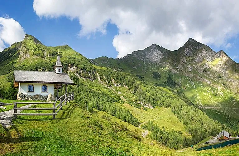 Chapelle à Bad Gastein devant un décor alpin verdoyant sous un ciel bleu