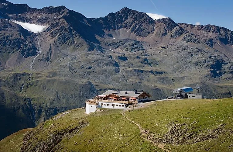 Letní turistika v Obergurgl-Hochgurgl s výhledem na zelené horské pastviny a Ötztalské Alpy.