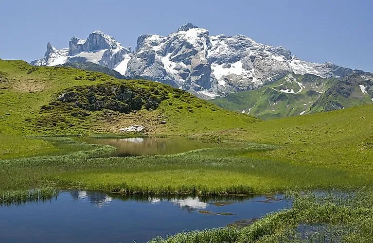 Alpine summer landscape with lake and snow-capped mountains in Vorarlberg