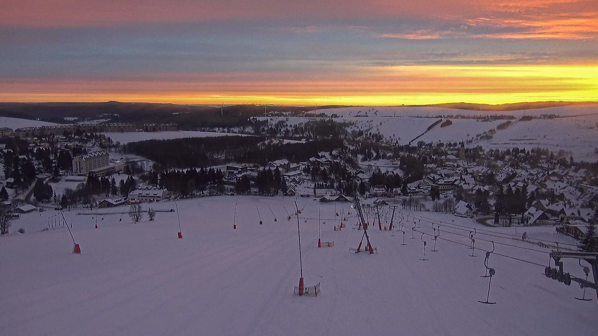 Skihang am Fichtelberg in Oberwiesenthal bei Sonnenaufgang mit verschneiter Winterlandschaft