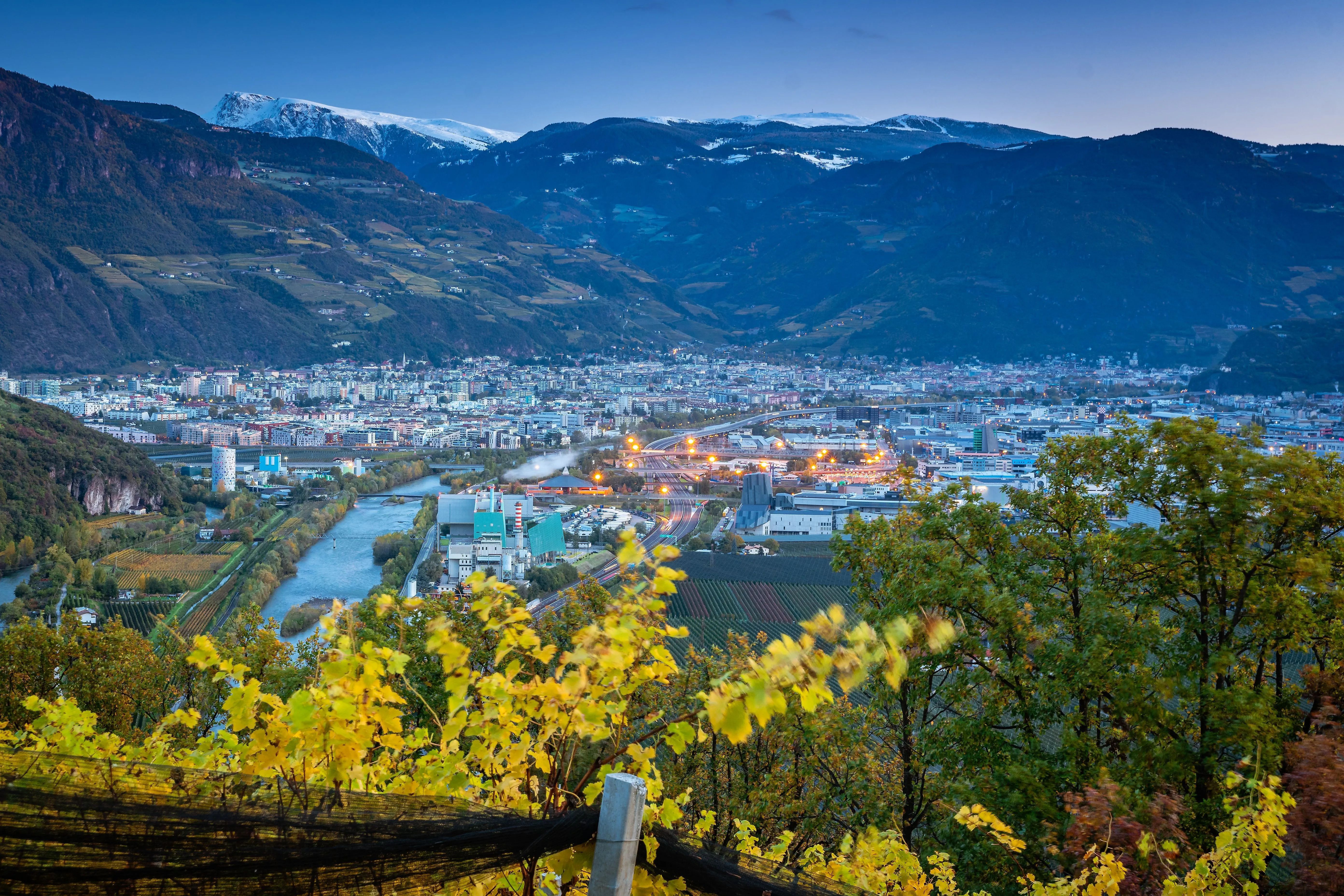 Uitzicht op Bolzano in Zuid-Tirol met rivier de Adige, wijngaarden en bergpanorama bij schemering