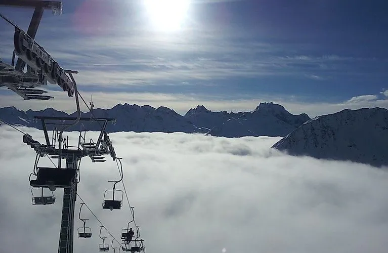 Albonagratbahn chairlift above the clouds with panoramic views of the Arlberg ski area