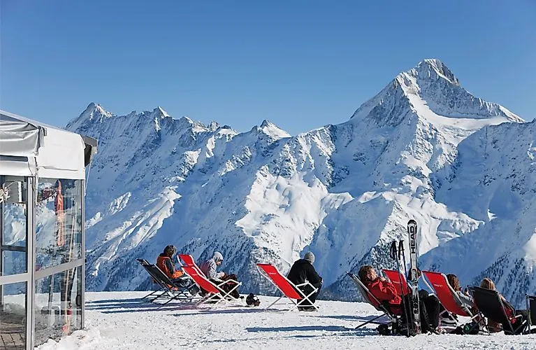 Sonnenliegen mit Panoramablick auf die verschneiten Walliser Alpen im Skigebiet Lauchernalp
