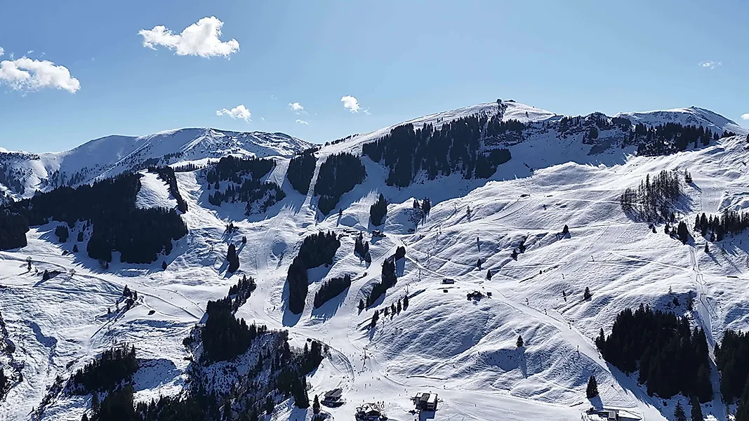 Zimní krajina v Maria Alm na Hochkönigu se zasněženými sjezdovkami a alpským horským panoramatem