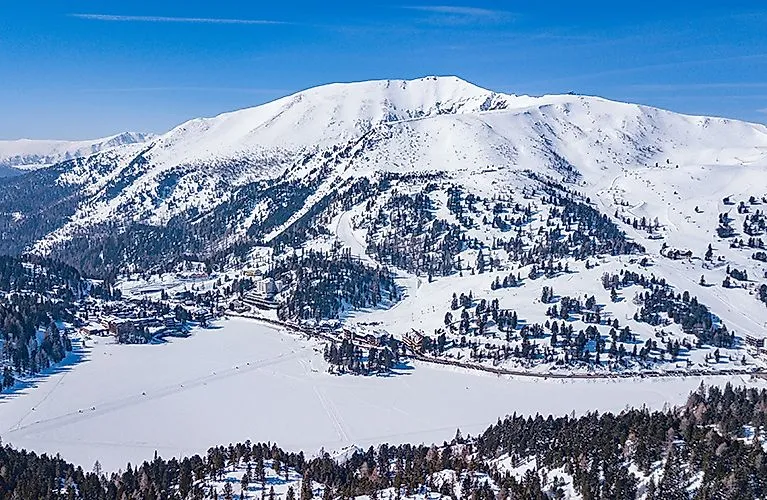 Turracher See nevado con vistas a la estación de esquí y las montañas circundantes