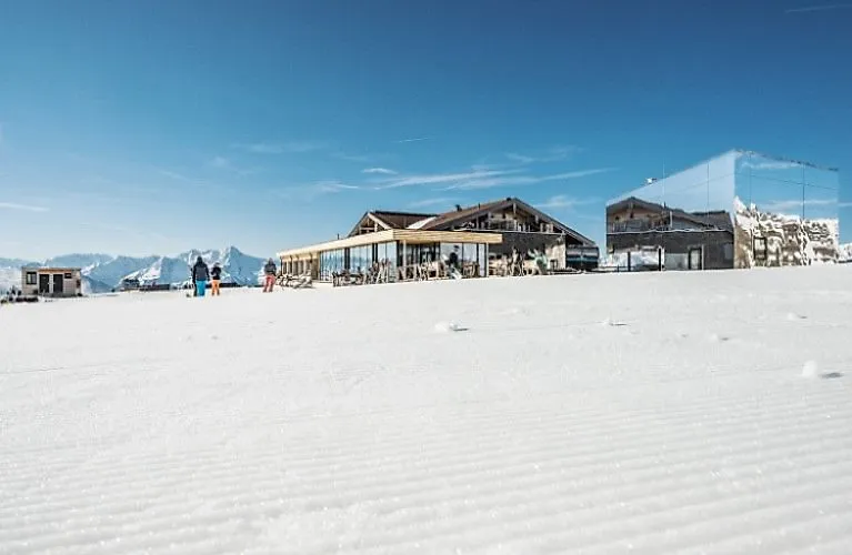 Chata Kristallhütte v zasněžené lyžařské oblasti s panoramatickým výhledem