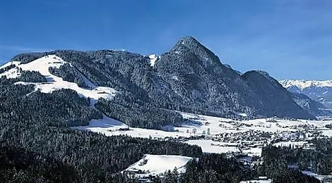 Snow-covered winter landscape with a view of Reith im Alpbachtal and the surrounding mountains in Tyrol.