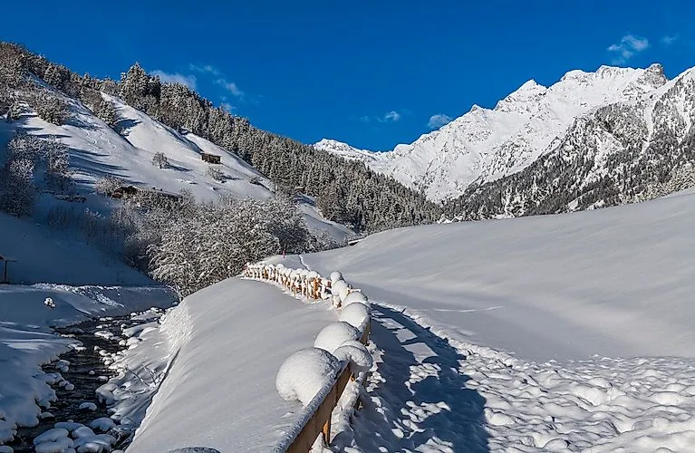 Sentiero invernale innevato a Gossensass con vista sulle Alpi innevate.