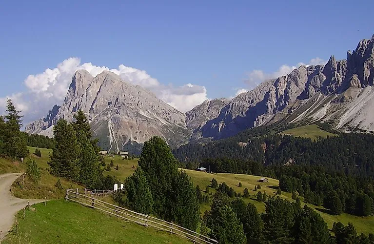 Letní krajina v Brixenu s výhledem na Dolomity a zelené alpské louky.