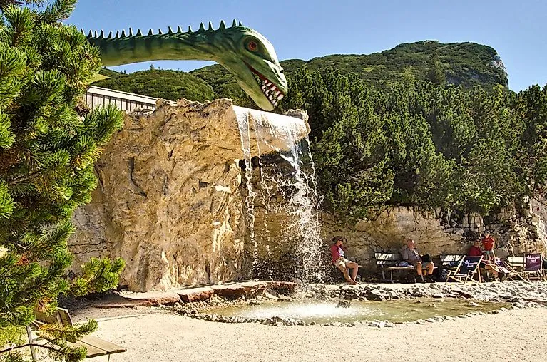 Vodní hřiště s postavou dinosaura v triasovém parku Waidring na Steinplatte