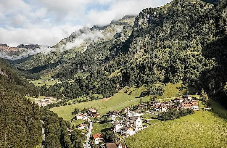 Vista estiva di Gossensass con la sua chiesa, immersa nel paesaggio montano dell'Alto Adige.