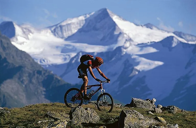 Mountain biker rides against an impressive mountain backdrop in the Wildkogel Arena