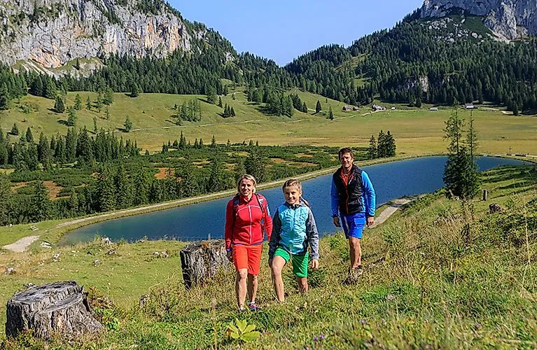 Family hiking along a mountain lake near Spital am Pyhrn in Upper Austria in summer