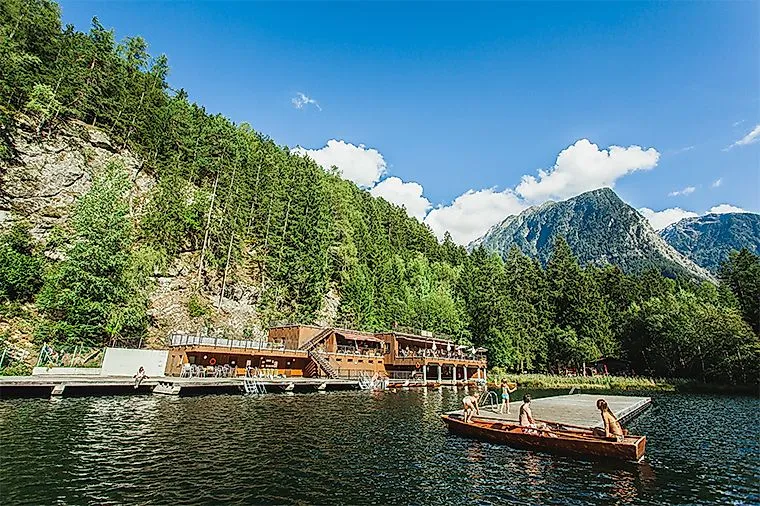 Děti se plaví na lodičkách před lázněmi na jezeře Piburger See za slunečného letního dne