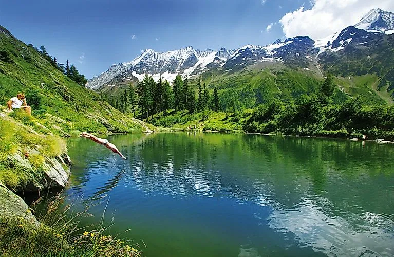 Mountain lake near Wiler, surrounded by green countryside and high mountains